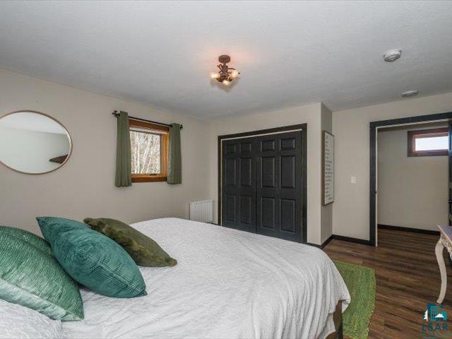 5508 Nordling Road Duluth, MN 55804 - Photo 22 of 58 Bedroom with radiator heating unit, dark wood finished floors, and a closet
