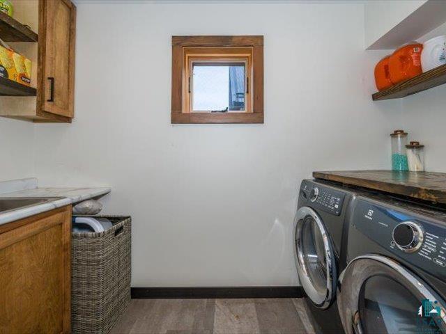 5508 Nordling Road Duluth, MN 55804 - Photo 28 of 58 Laundry room with separate washer and dryer, light wood-style floors, and cabinet space