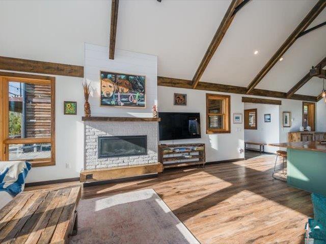 5508 Nordling Road Duluth, MN 55804 - Photo 5 of 58 Living area with a brick fireplace, beam ceiling, dark wood-style flooring, and high vaulted ceiling
