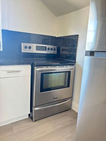 a stove top oven sitting inside of a kitchen