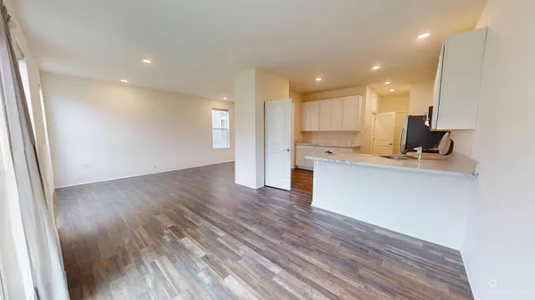 a view of kitchen with cabinets stainless steel appliances and wooden floor