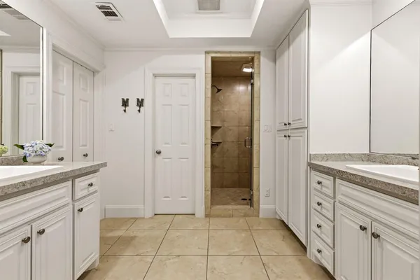 a spacious bathroom with a granite countertop sink a mirror and a bathtub