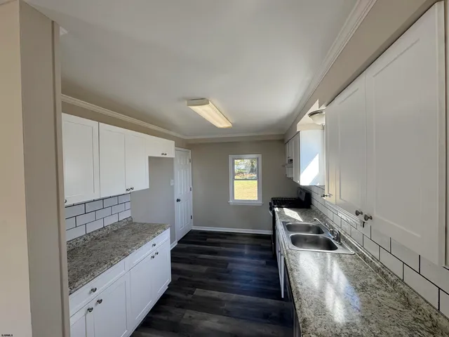 a view of a kitchen with wooden floor and staircase
