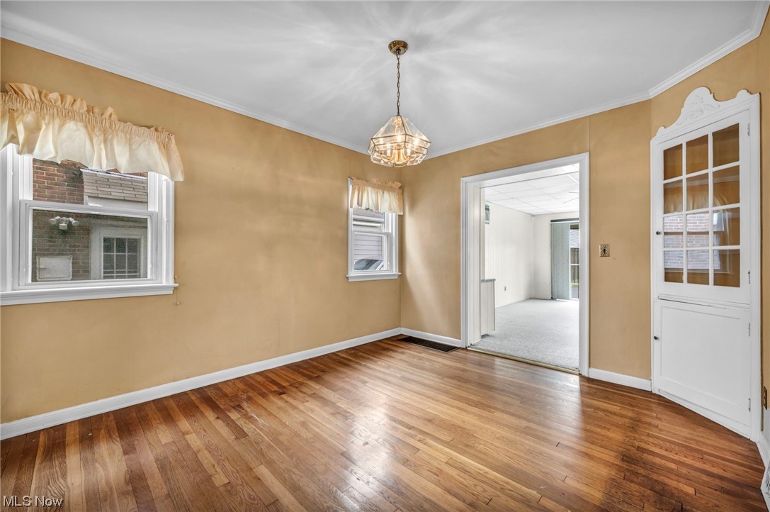 3946 Lansdale Road Cleveland, OH 44118 - Photo 16 of 42 Dining Room with a notable chandelier, crown molding, and wood-type flooring