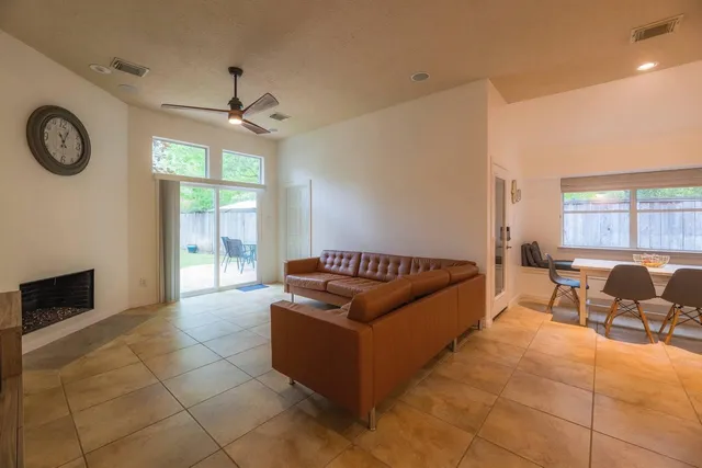 a living room with couches a large mirror with wooden floor and windows