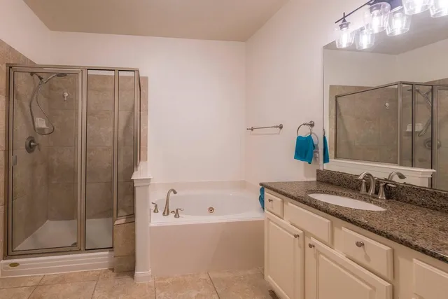 a bathroom with a granite countertop sink mirror and shower