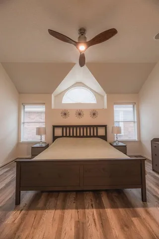 a bedroom with a large bed and a chandelier