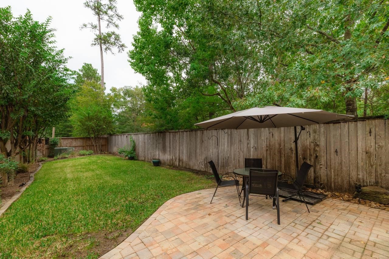 6 Avenswood Place Spring, TX 77382 - Photo 19 of 22 a backyard of a house with table and chairs