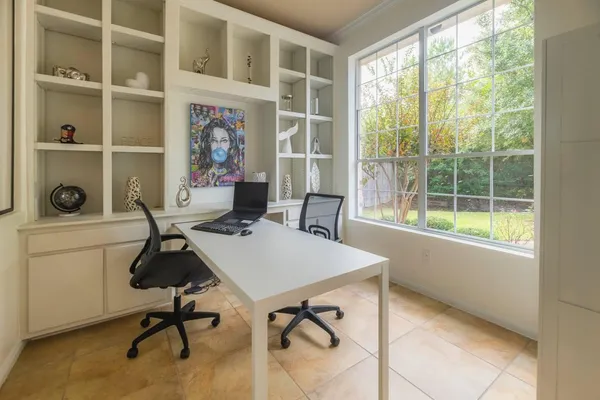 a view of a workspace with furniture and a window