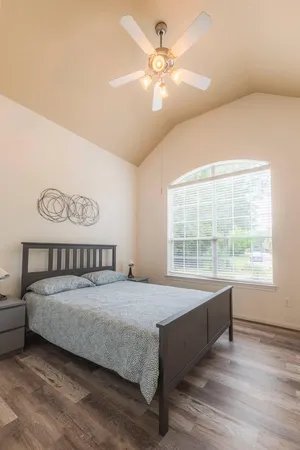a bedroom with a large bed and a chandelier