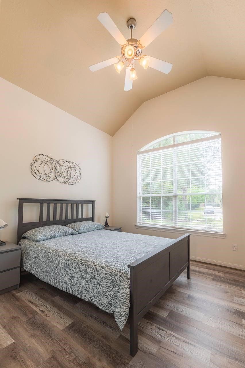 6 Avenswood Place Spring, TX 77382 - Photo 4 of 22 a bedroom with a large bed and a chandelier