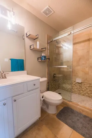 a bathroom with a sink a toilet and shower
