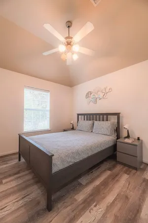a spacious bedroom with a bed and a chandelier