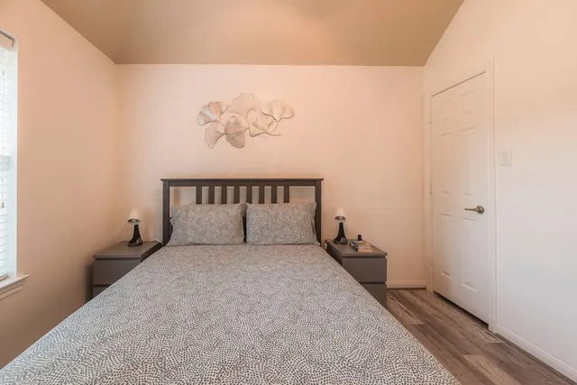 a large bed sitting in a bedroom next to a window