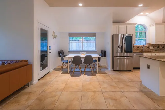 a kitchen with stainless steel appliances granite countertop a refrigerator and a stove top oven
