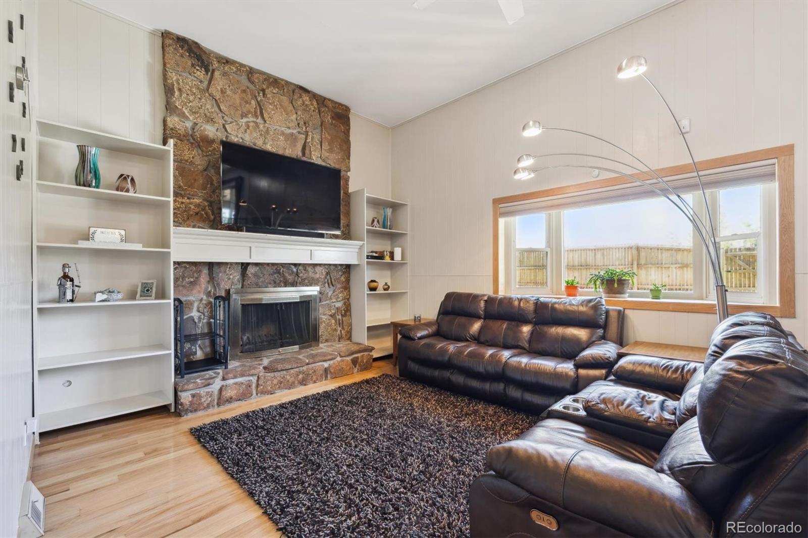 8403 Chase Drive Arvada, CO 80003 - Photo 16 of 39 a living room with furniture flat screen tv and a fireplace