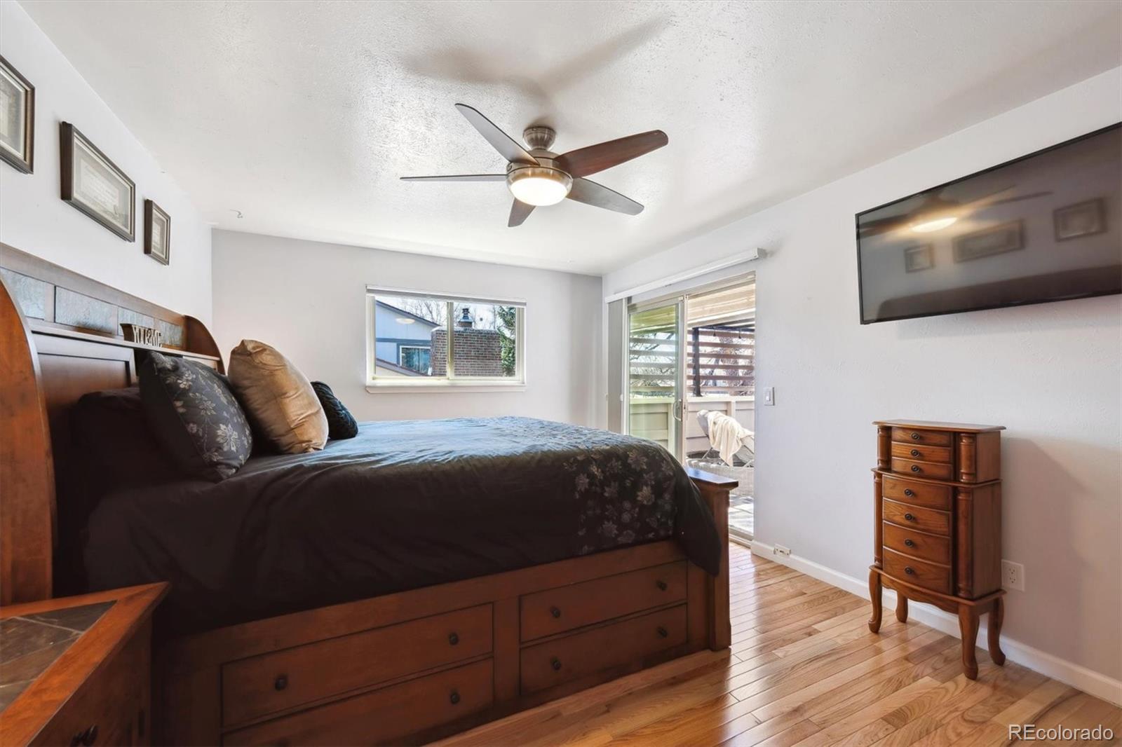 8403 Chase Drive Arvada, CO 80003 - Photo 22 of 39 a bedroom with a bed a flat screen tv and couches
