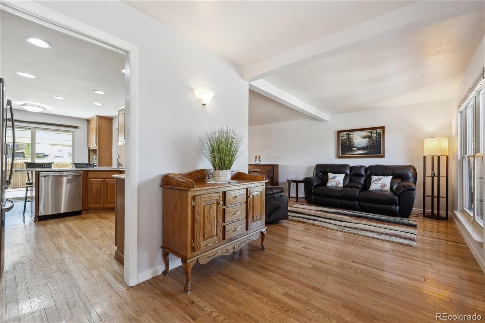 8403 Chase Drive Arvada, CO 80003 - Photo 3 of 39 a living room with furniture a fireplace and a wooden floor