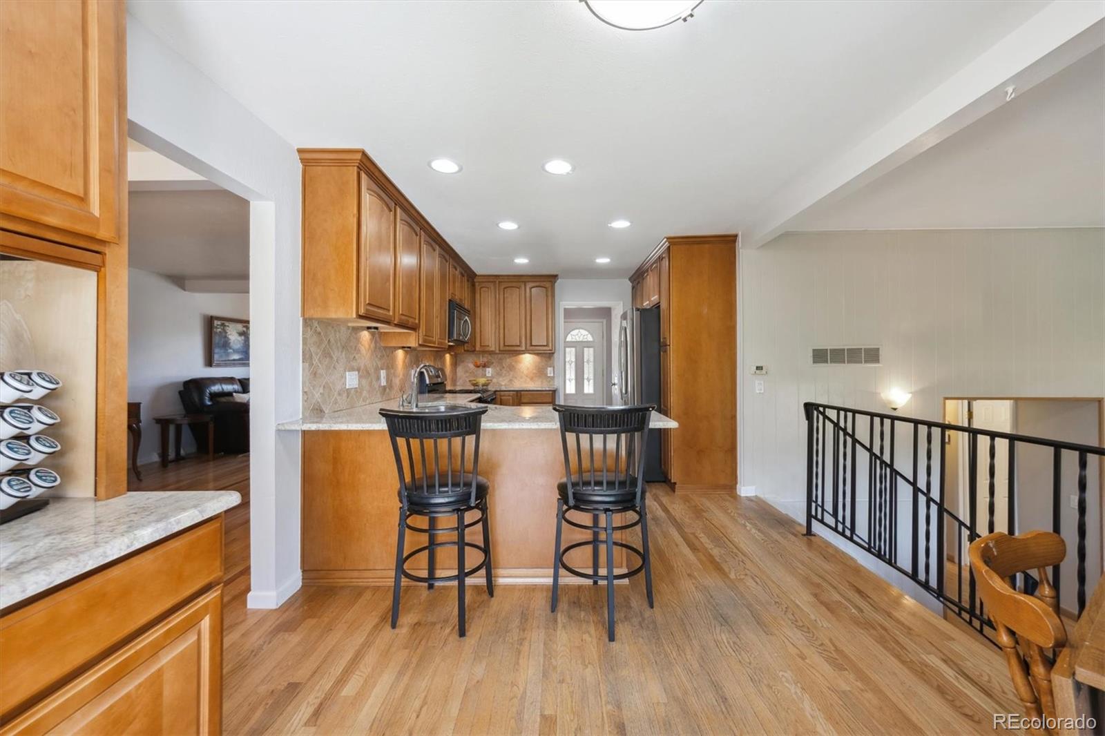 8403 Chase Drive Arvada, CO 80003 - Photo 5 of 39 a kitchen with stainless steel appliances granite countertop wooden floor a refrigerator and a stove top oven