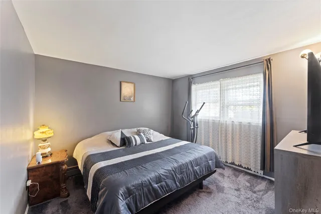 a bedroom with a bed and a lamp next to a window