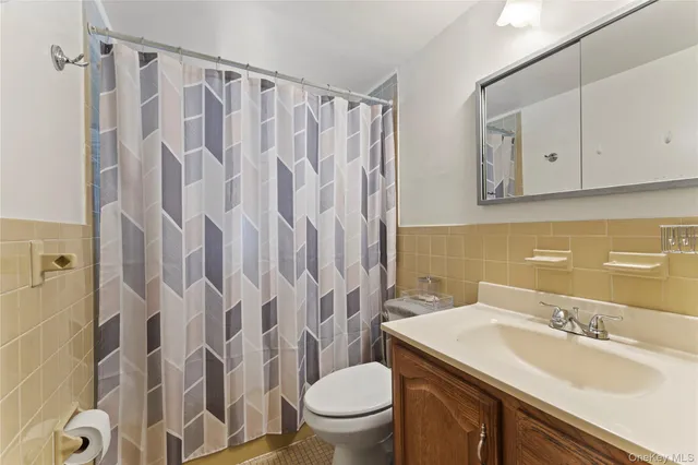 a bathroom with a granite countertop sink a toilet and a mirror
