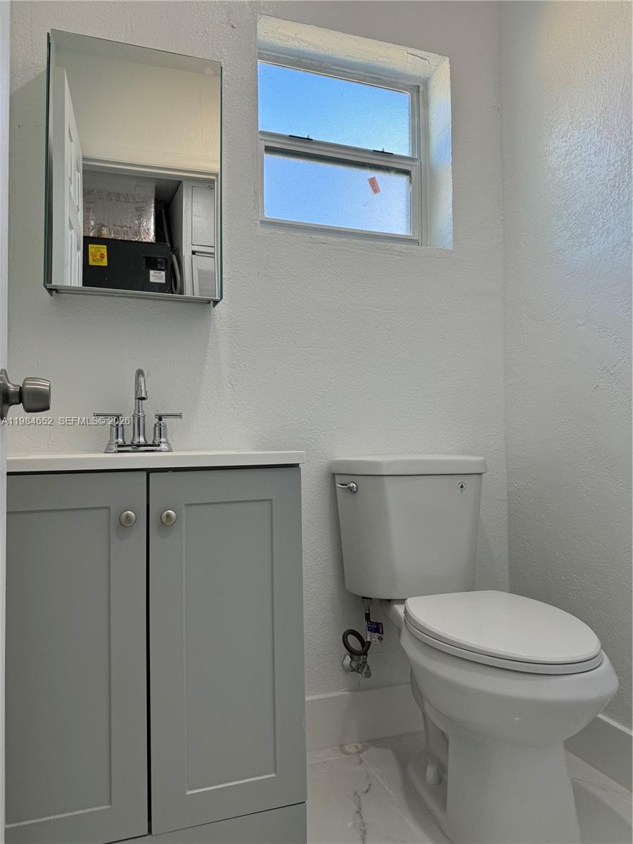 2400 North 57th Way Hollywood, FL 33021 - Photo 8 of 9 a bathroom with a toilet a sink and mirror