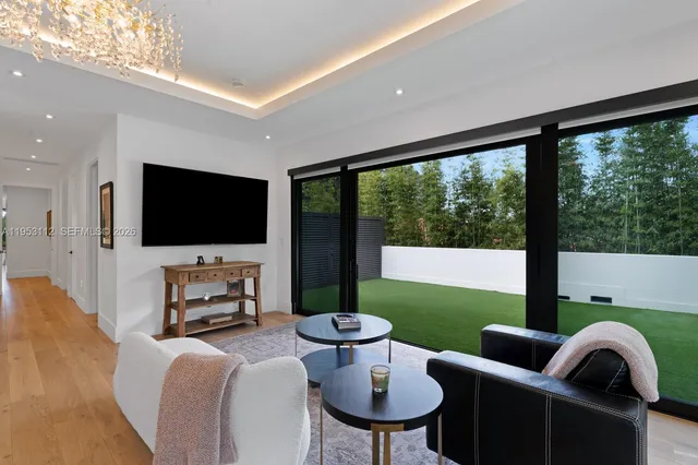 a view of a patio with table and chairs potted plants with floor to ceiling window