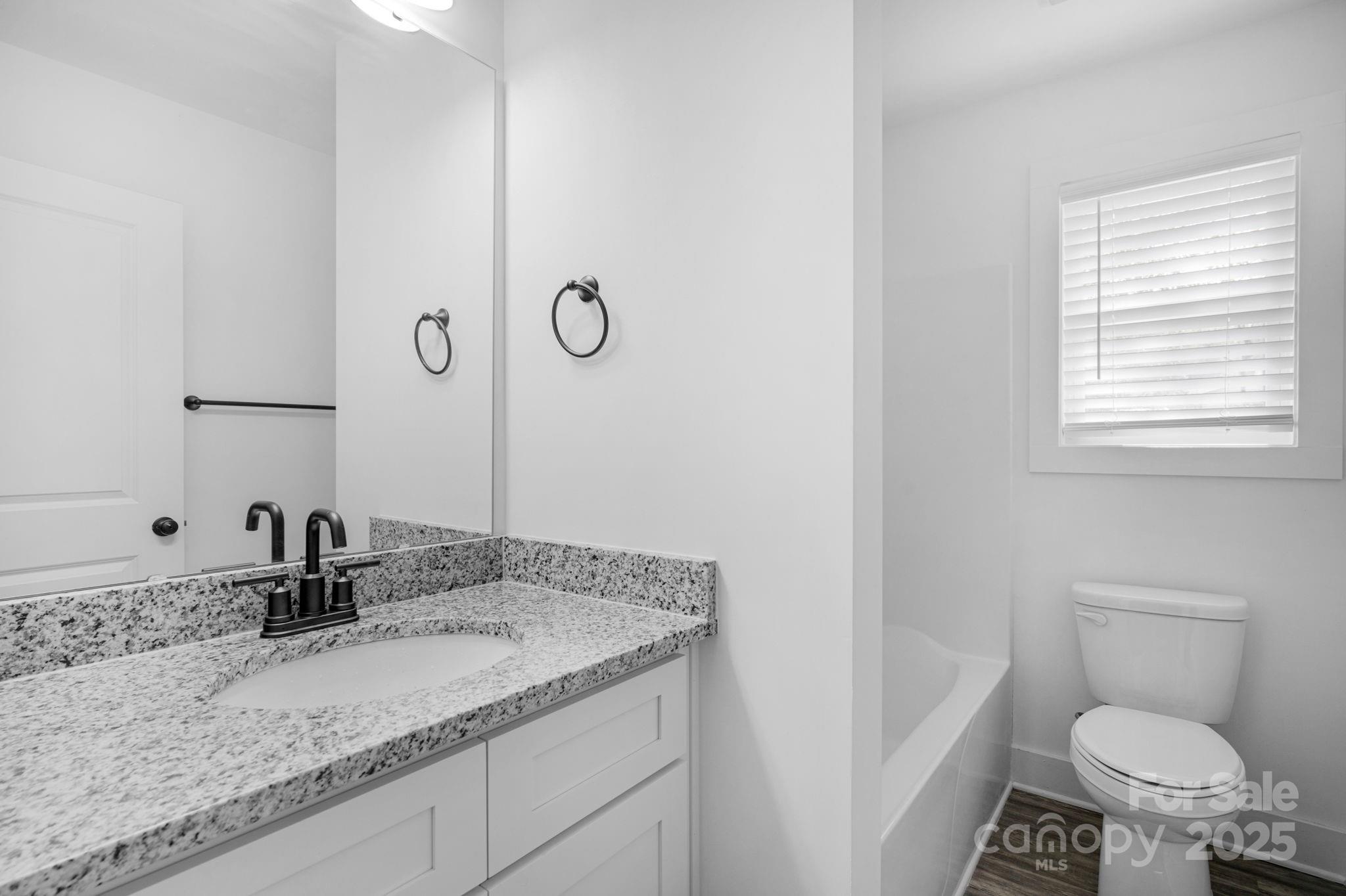 324 Ashford Street Chester, SC 29706 - Photo 11 of 20 a bathroom with a granite countertop sink and a mirror