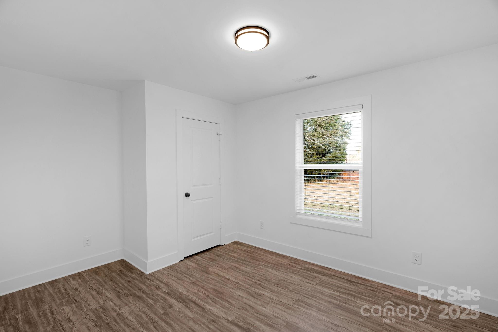 324 Ashford Street Chester, SC 29706 - Photo 19 of 20 an empty room with wooden floor and windows