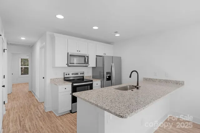 a kitchen with stainless steel appliances granite countertop a sink refrigerator and microwave