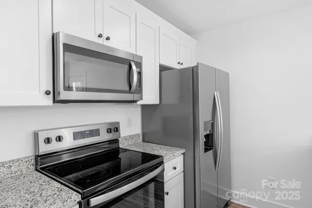 a kitchen with stainless steel appliances granite countertop a stove microwave and refrigerator