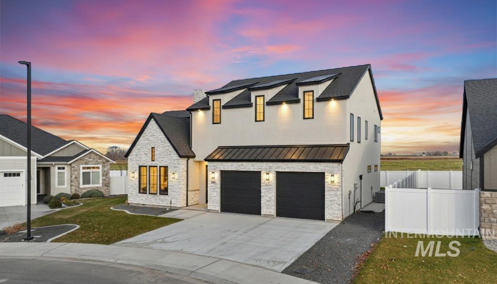 696 Full Moon Way Twin Falls, ID 83301 - Photo 1 of 48 View of front of house with stone siding, a standing seam roof, a metal roof, concrete driveway, and an attached garage