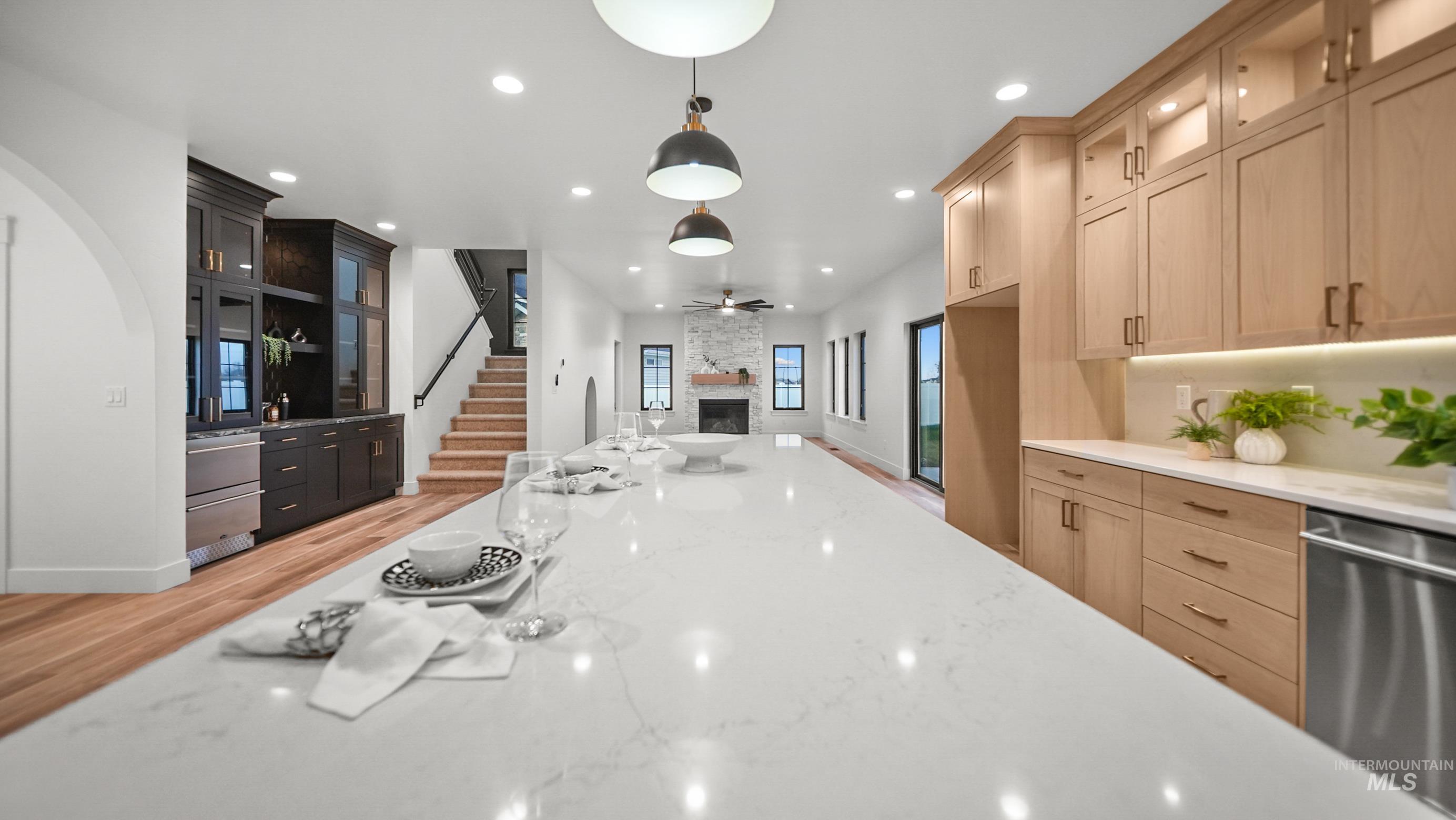 696 Full Moon Way Twin Falls, ID 83301 - Photo 10 of 48 Kitchen with glass insert cabinets, a fireplace, light brown cabinetry, light stone counters, and dishwasher