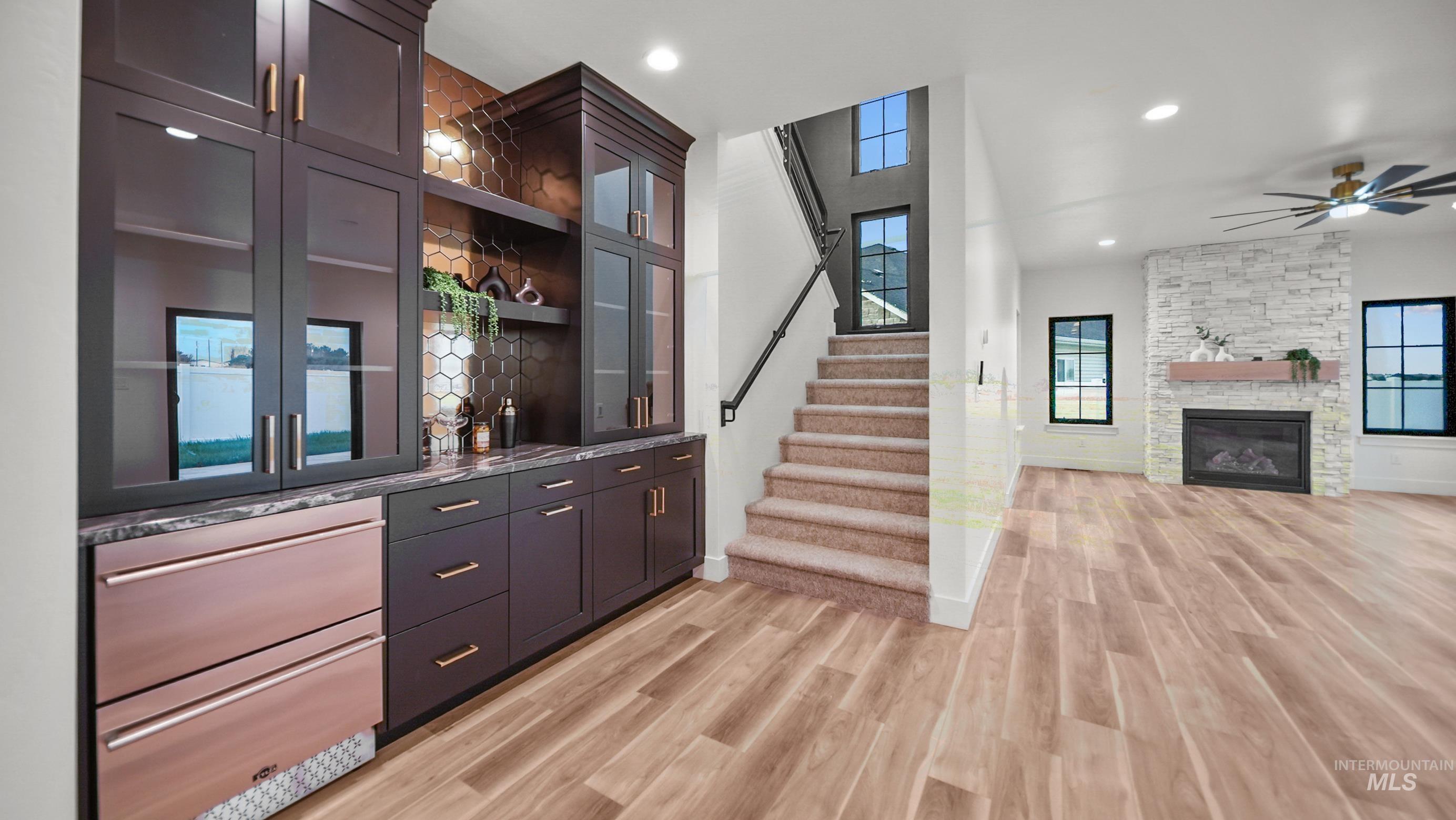 696 Full Moon Way Twin Falls, ID 83301 - Photo 11 of 48 Indoor wet bar with open shelves, stairway, light wood-type flooring, recessed lighting, and a stone fireplace