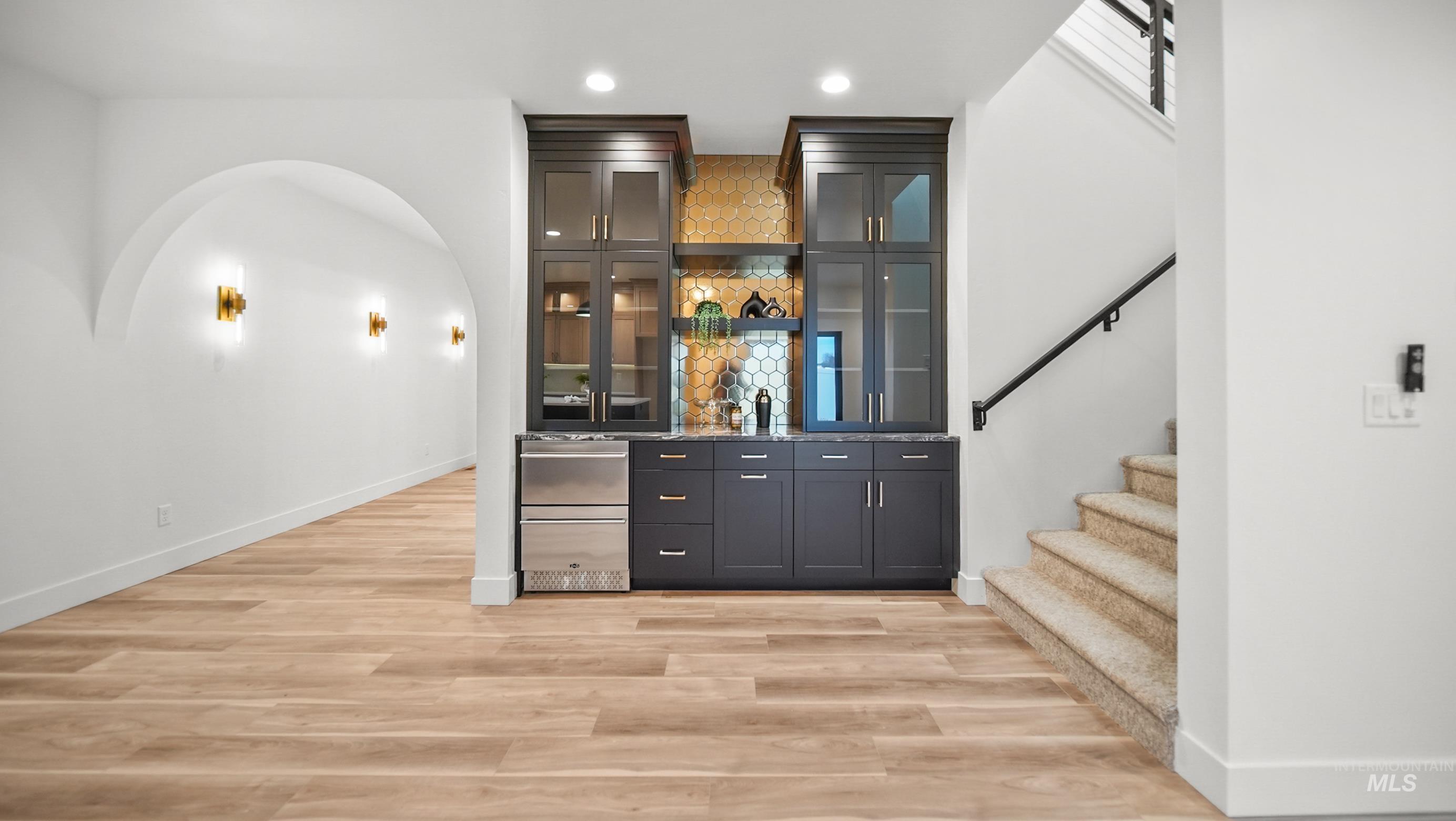 696 Full Moon Way Twin Falls, ID 83301 - Photo 16 of 48 Indoor wet bar featuring recessed lighting, stairway, glass insert cabinets, light wood-style floors, and dark cabinetry