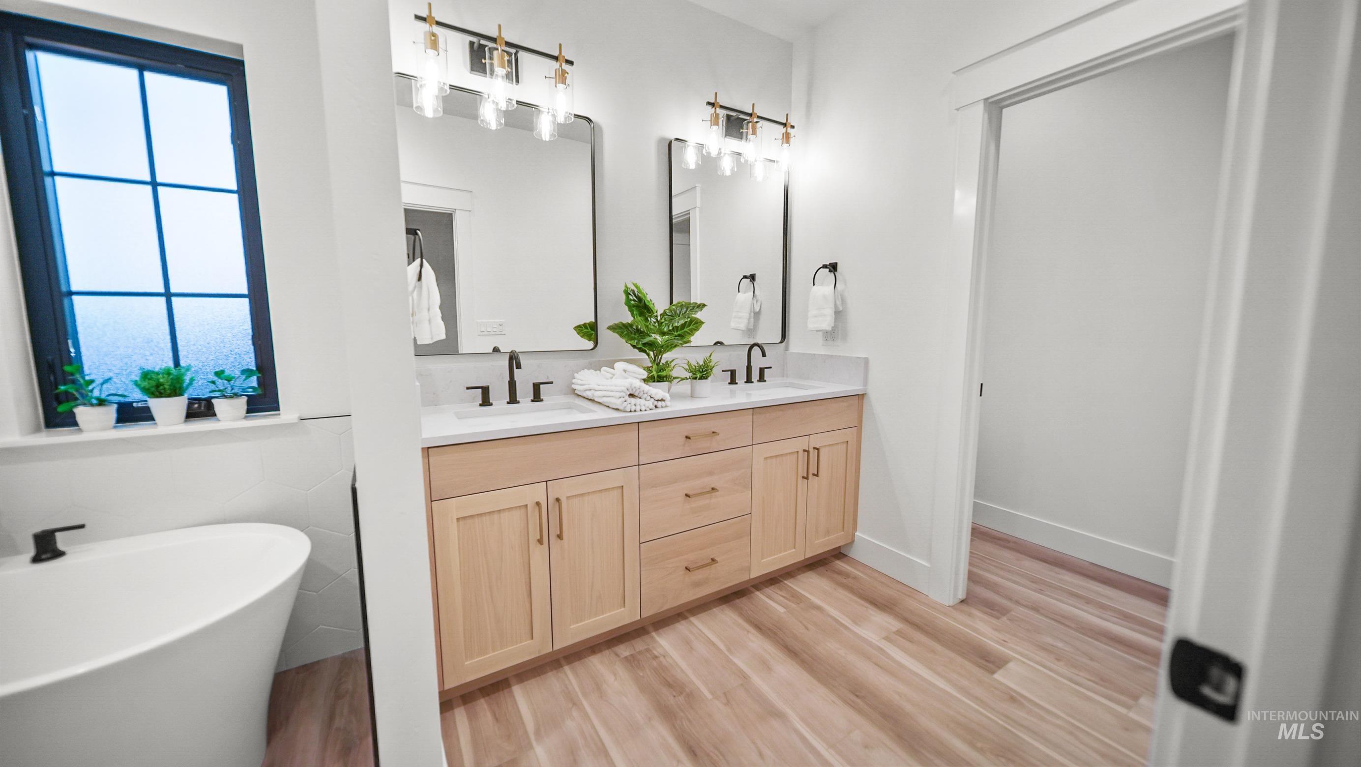 696 Full Moon Way Twin Falls, ID 83301 - Photo 26 of 48 Bathroom featuring double vanity, a freestanding bath, plenty of natural light, and light wood finished floors