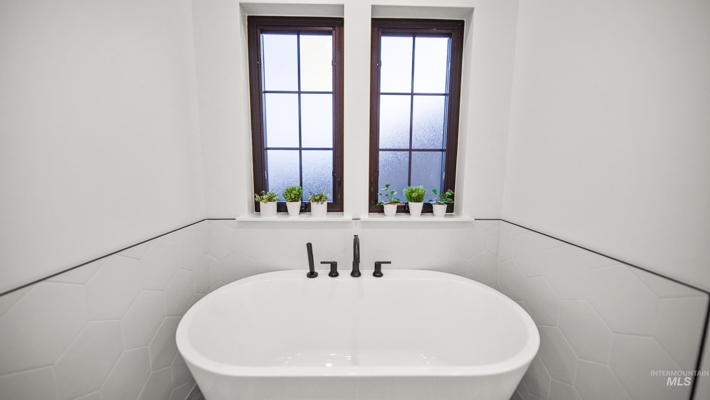 696 Full Moon Way Twin Falls, ID 83301 - Photo 27 of 48 Bathroom with wainscoting, tile walls, and a freestanding tub
