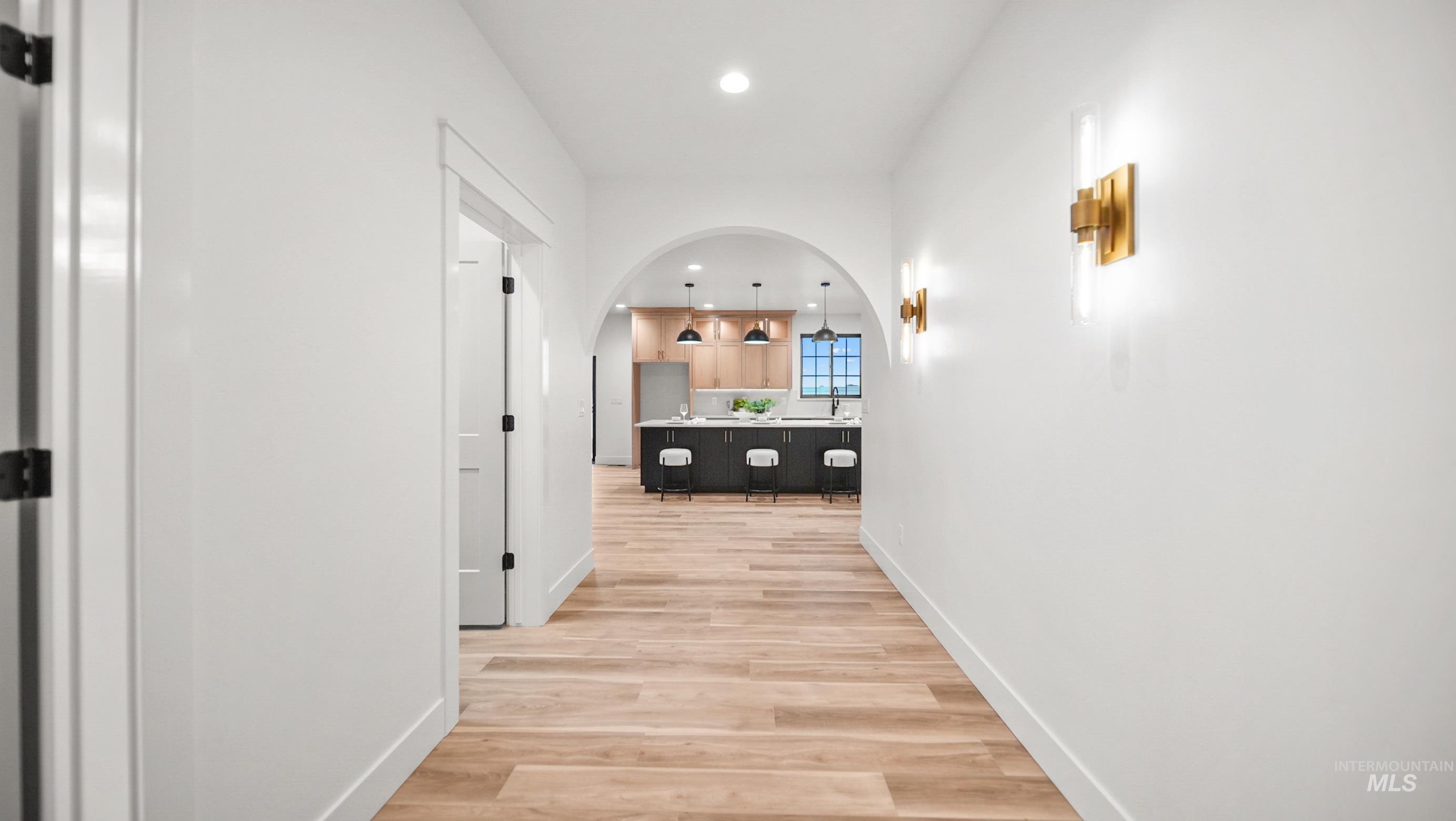 696 Full Moon Way Twin Falls, ID 83301 - Photo 3 of 48 Hallway featuring arched walkways, light wood-style floors, and recessed lighting