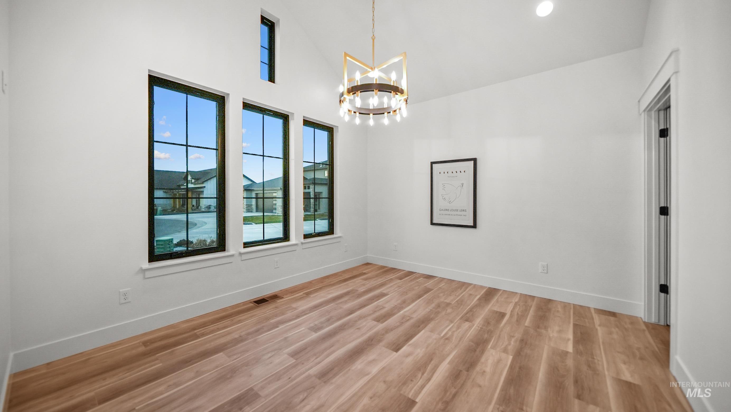 696 Full Moon Way Twin Falls, ID 83301 - Photo 5 of 48 Unfurnished dining area with light wood finished floors, a chandelier, and high vaulted ceiling