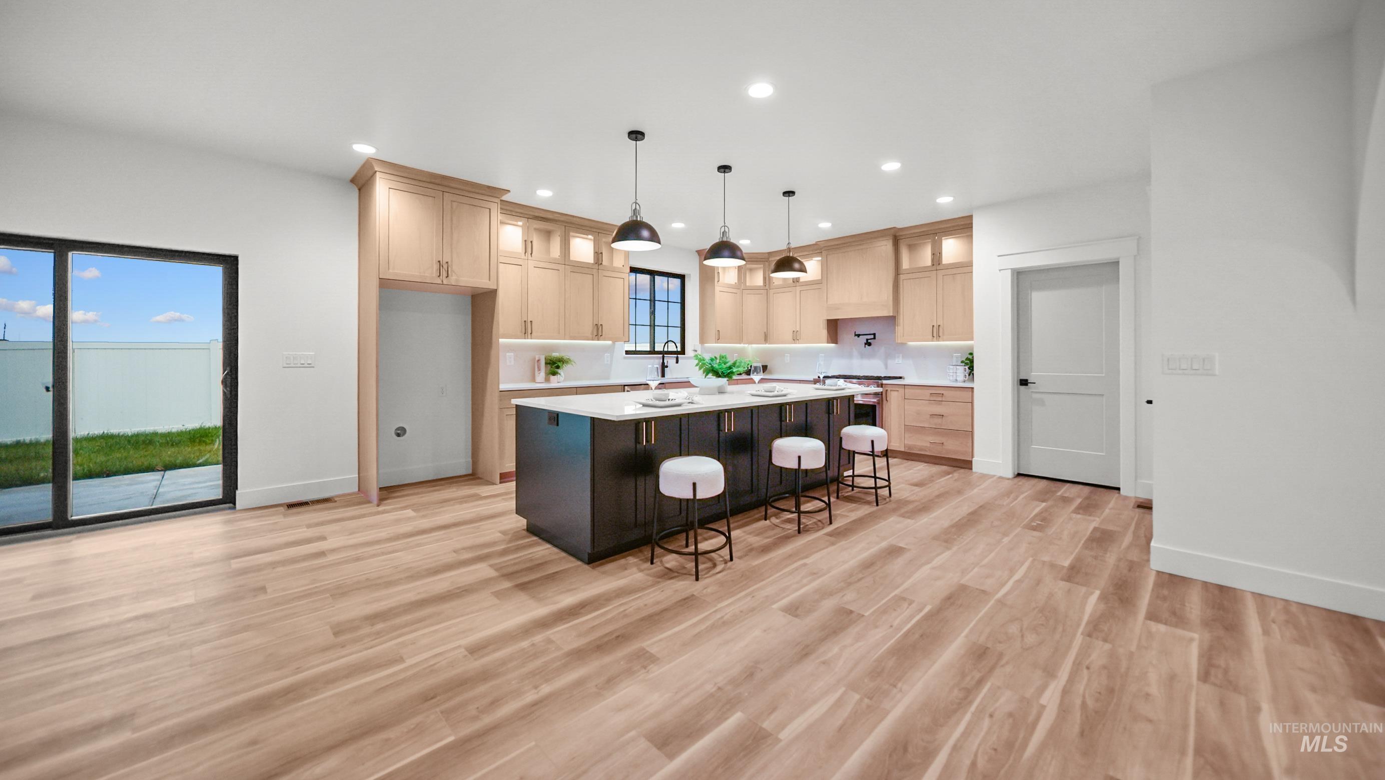 696 Full Moon Way Twin Falls, ID 83301 - Photo 9 of 48 Kitchen featuring a kitchen breakfast bar, glass insert cabinets, light brown cabinets, recessed lighting, and a center island