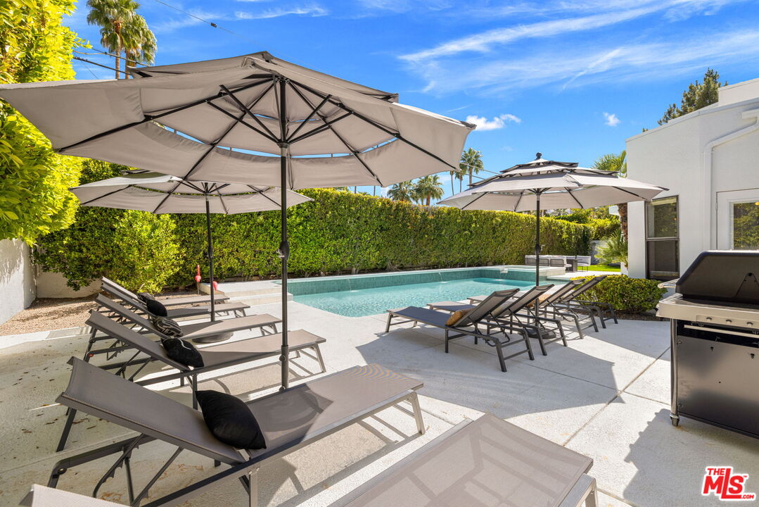 1414 Sagebrush Road Palm Springs, CA 92264 - Photo 44 of 48 a view of a patio with table and chairs under an umbrella