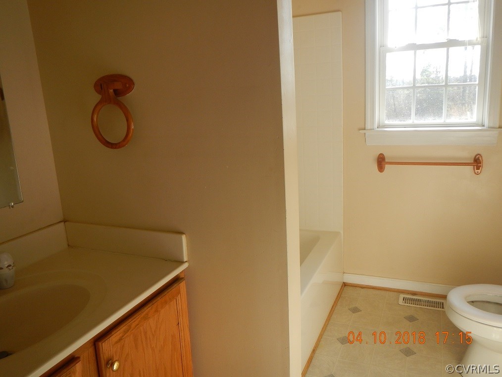 24480 Johnson Road Jetersville, VA 23083 - Photo 10 of 16 a bathroom with a granite countertop sink and a toilet