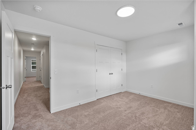 445 950 South Ogden, UT 84404 - Photo 23 of 28 Unfurnished bedroom featuring light carpet and a closet