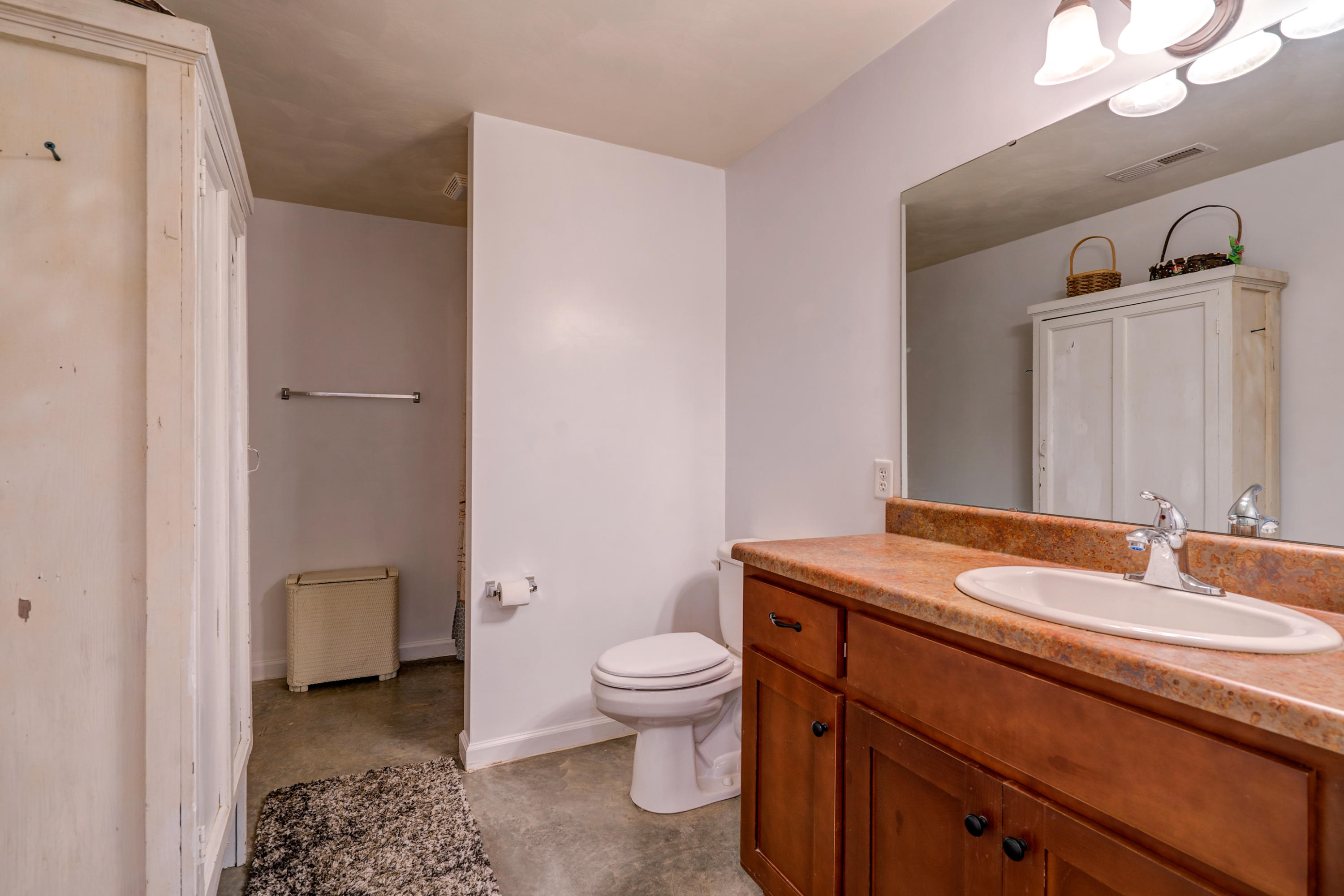 3007 Sandy Level Road Goodview, VA 24095 - Photo 49 of 51 a bathroom with a granite countertop sink a toilet and a mirror