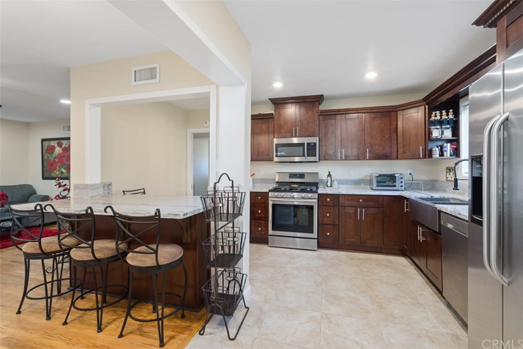 7955 Brookpark Road Downey, CA 90240 - Photo 11 of 27 a kitchen with stainless steel appliances kitchen island granite countertop a refrigerator and cabinets