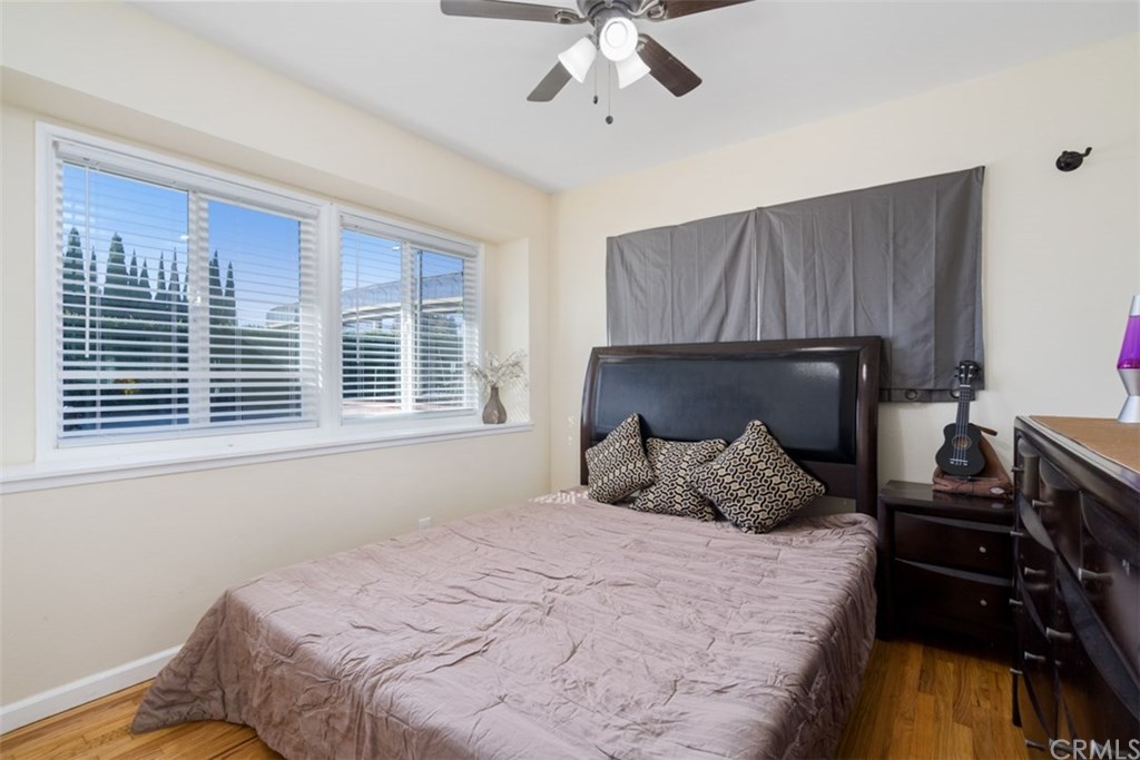 7955 Brookpark Road Downey, CA 90240 - Photo 17 of 27 a bedroom with a bed and wooden floor