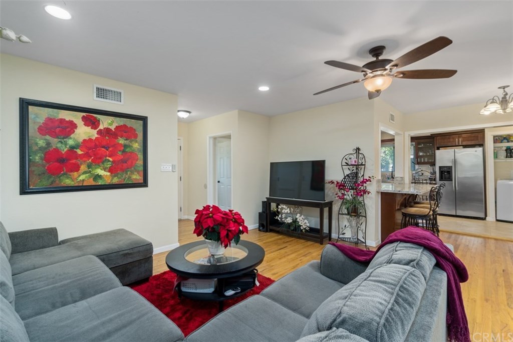 7955 Brookpark Road Downey, CA 90240 - Photo 3 of 27 a living room with furniture and a flat screen tv with kitchen view