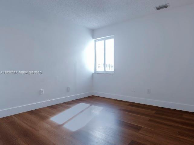 11475 Southwest 181st Street, Unit A Miami, FL 33157 - Photo 12 of 18 an empty room with wooden floor and windows