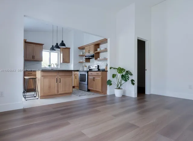 a view of a kitchen with a sink wooden floor and a living room