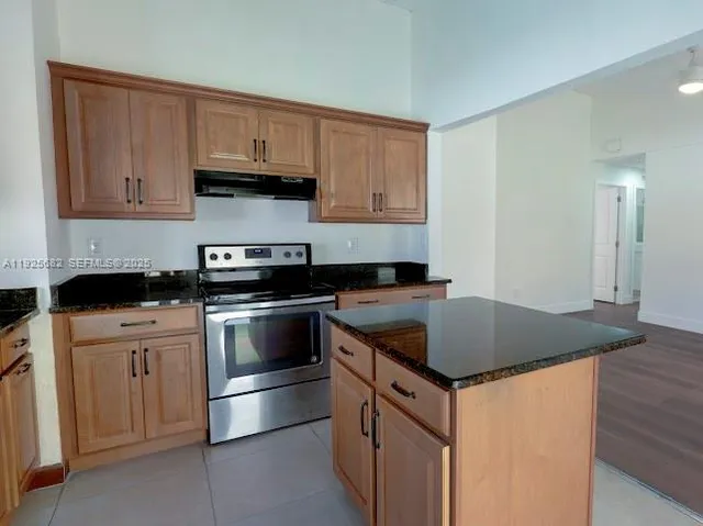 a kitchen with stainless steel appliances granite countertop a stove a sink and a granite counter tops